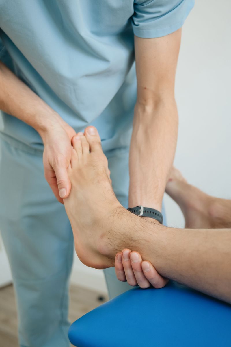 A physiotherapist examining a patient's ankle