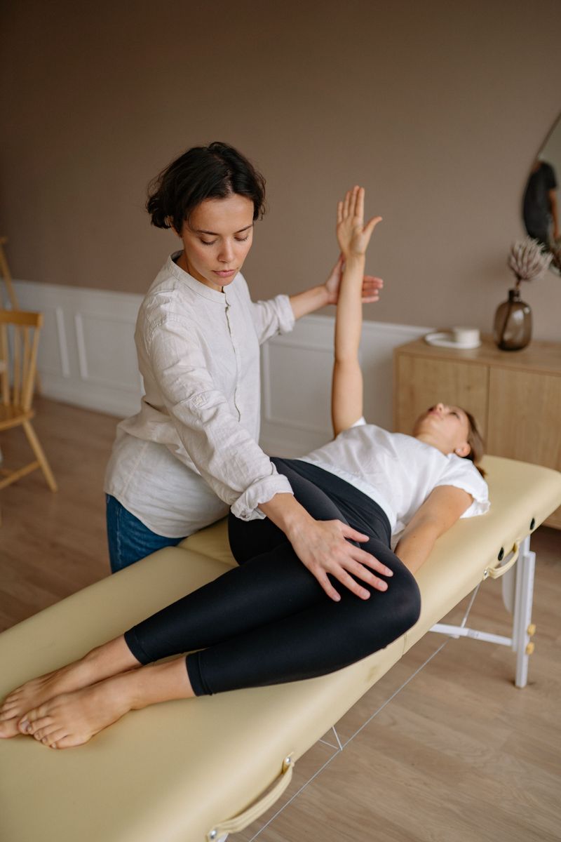 A therapist guiding a patient through an arm and hip movement