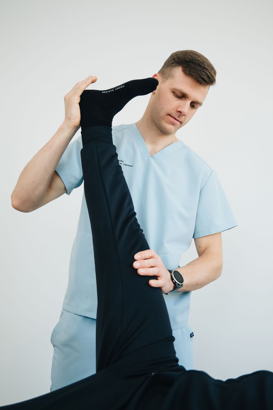A physiotherapist gently stretching a patient's leg during a treatment session